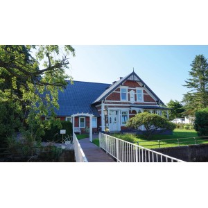 Haus mit anthrazitfarbenem Weckman Pfannenblech Typ 2 Dach. Klassische Ziegeloptik.