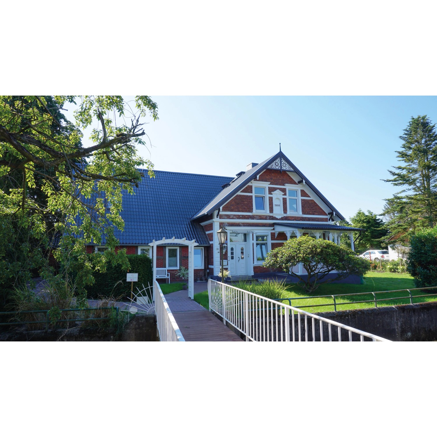 Haus mit anthrazitfarbenem Weckman Pfannenblech Typ 2 Dach. Klassische Ziegeloptik.