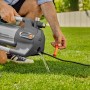 Gardena Gartenpumpe 6500 SilentComfort in Nutzung: Wasser fließt aus der grauen Pumpe auf Rasen.