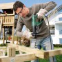 Mann bohrt mit dem Bosch Bohrhammer PBH 2800 RE in Holz. Der Bohrhammer ist grün und schwarz.