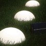 Solar-LED-Dekoleuchte Camporosso mit Halbkugeln und Solarpanel im Garten.