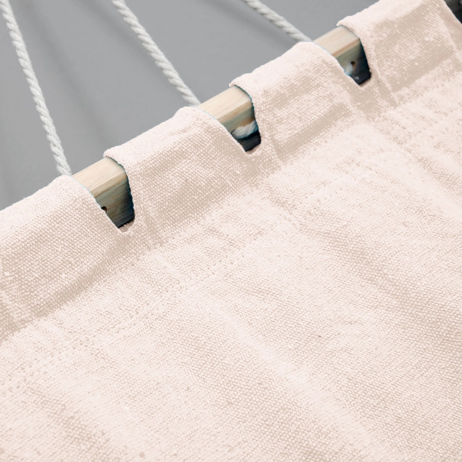 Detailaufnahme: Beige AMANKA Hängematte mit Holzstab und Seilaufhängung.
