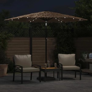 Brauner Sonnenschirm mit Strohdach und leuchtenden LEDs, auf einer Terrasse bei Nacht. Kippbarer Gartenschirm mit Stahlmast.