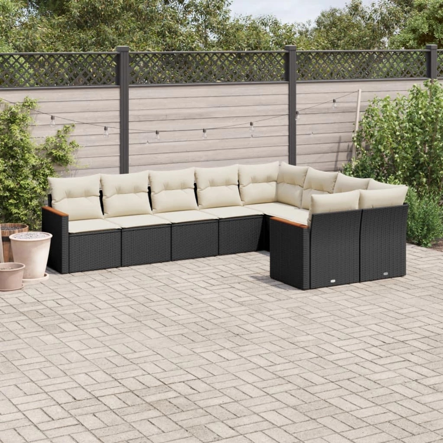 Schwarze 9-tlg. Garten-Sofagarnitur aus Polyrattan mit cremefarbenen Kissen.