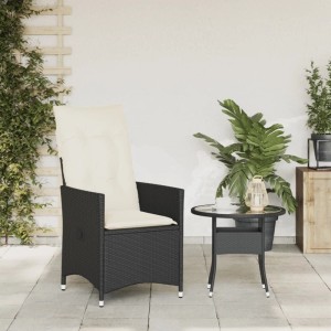 Schwarzer verstellbarer Poly Rattan Gartensessel mit cremeweißen Kissen auf gepflasterter Terrasse. Ideal für Garten.