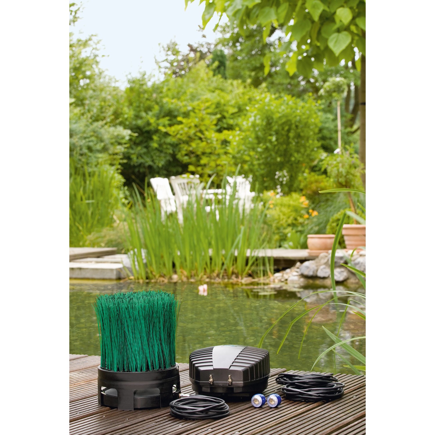 Oase OxyTex Set 1000 Teichbelüfter mit Filtermedium und Zubehör vor Gartenteich.