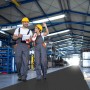 Schwarzer KARAT PVC Bodenbelag Diamond Cut als Meterware in Lagerhalle mit zwei Arbeitern.