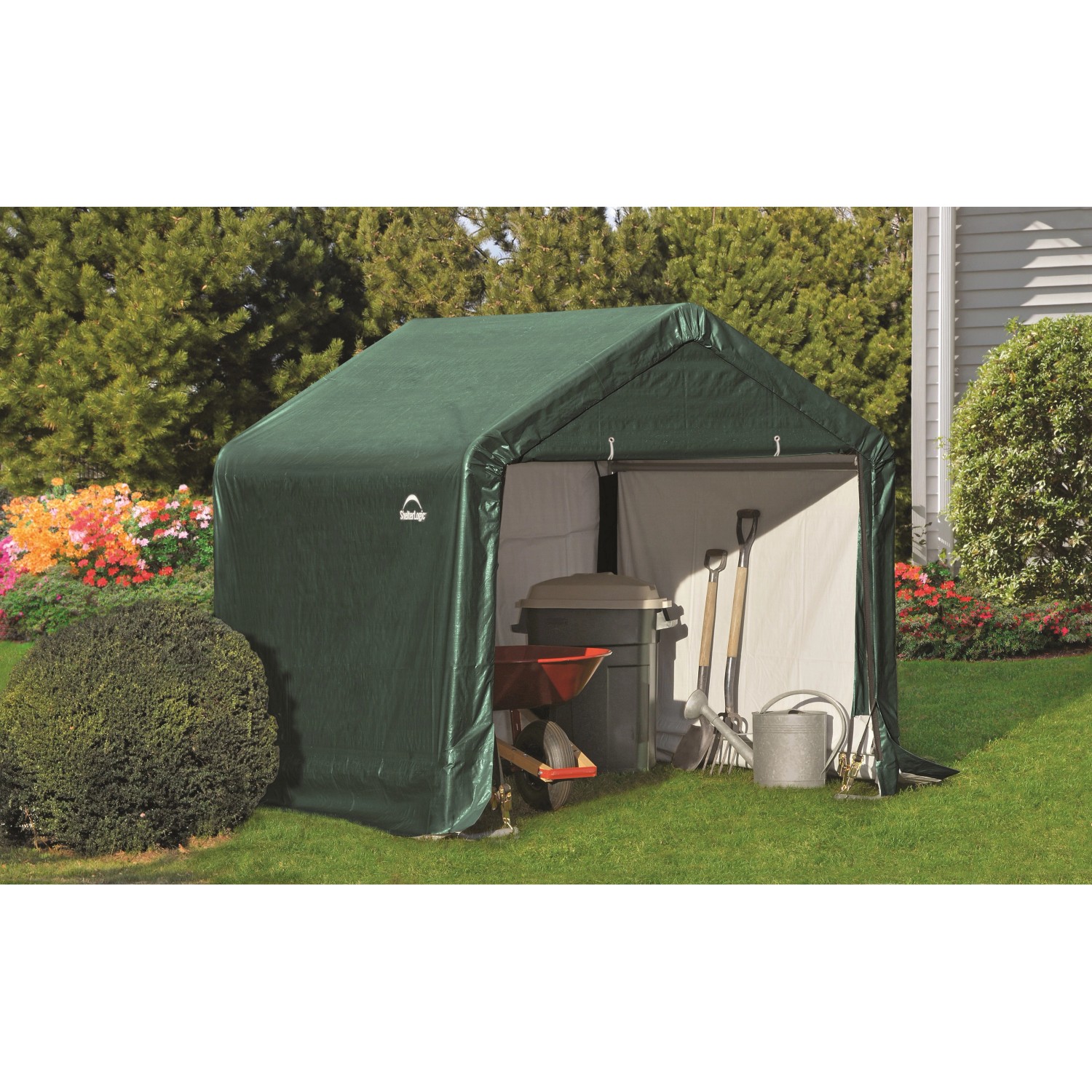 Grüne ShelterLogic Zeltgarage 180x180x180cm mit Gartengeräten im Garten.