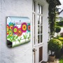 Edelstahl Briefkasten mit Zeitungsfach und buntem Blumenmotiv an einer weißen Hauswand.