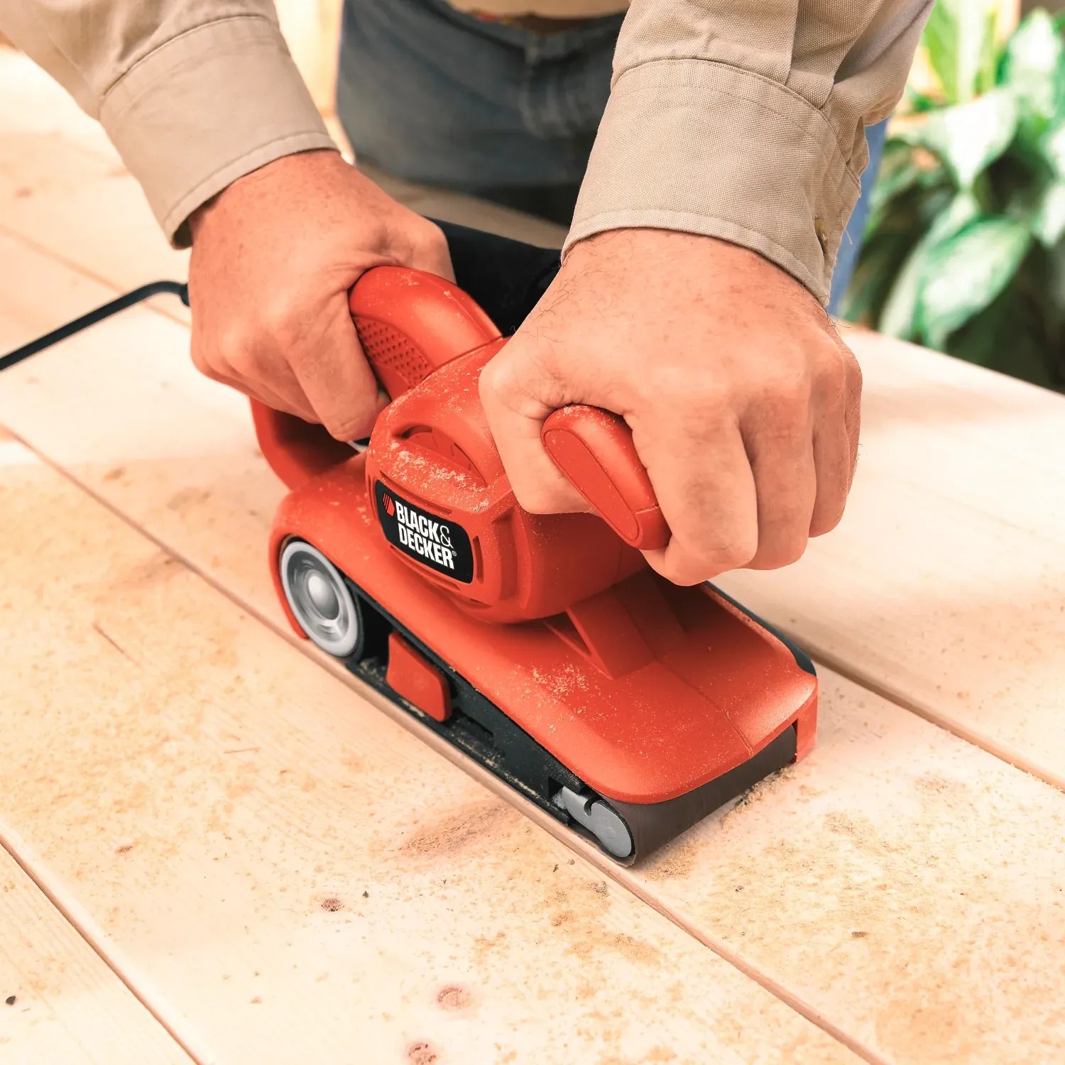 Black+Decker Bandschleifer KA86 in Aktion auf Holzoberfläche. Schleifmaschine für randnahes Arbeiten.