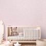 Rosa Vliestapete von A.S. Creation im Kinderzimmer über einem Babybett.