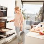 Frau misst mit Bosch UniversalTemp Infrarot-Thermometer die Temperatur im Ofen.