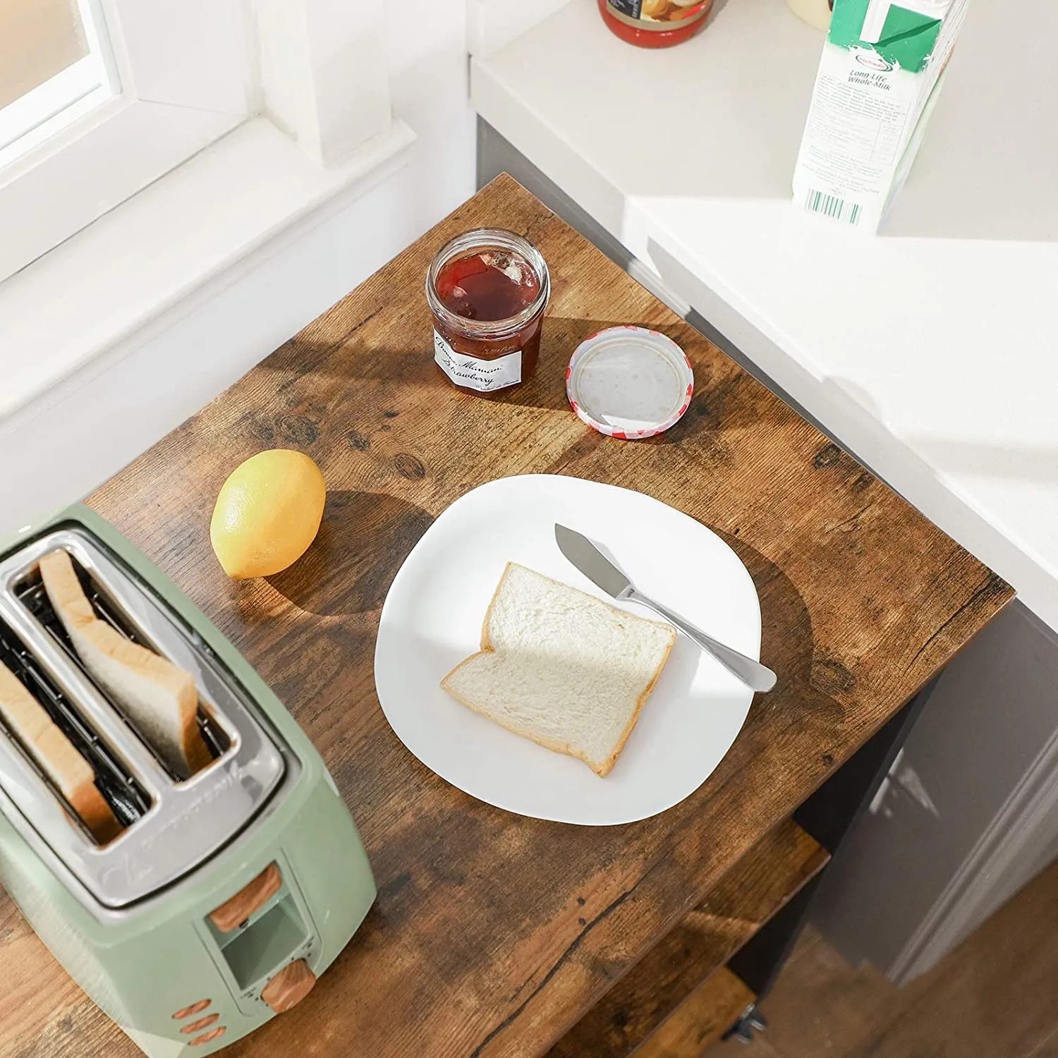 Vasagle Küchenregal mit Rollen, braun-schwarz, mit Toaster, Marmelade, Zitrone und Brot auf der Ablage.