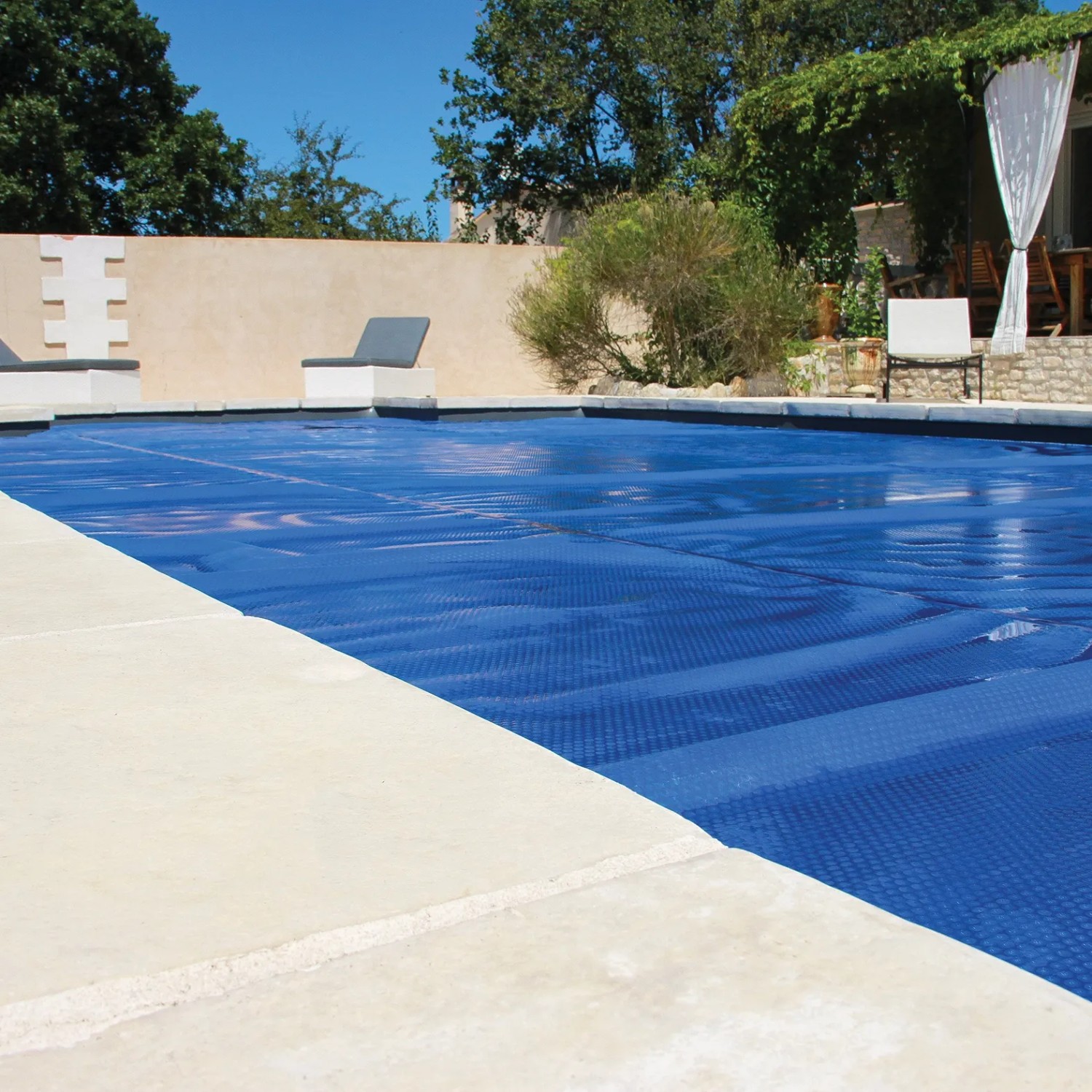 Blau schimmernde Summer Fun Solarfolie auf rundem Pool, schützt vor Verschmutzung und hält das Wasser warm.