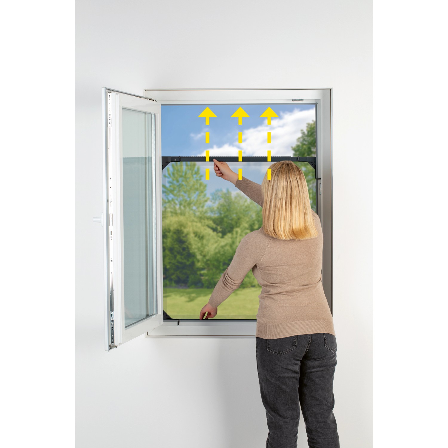 Frau montiert Easymaxx Moskitonetz Magic Fit (anthrazit) am Fenster. Fenster-Zubehör für Insektenschutz.