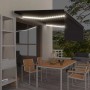 Anthrazitfarbene Markise mit LED-Beleuchtung und Rollo über Terrasse bei Nacht. Manuell einziehbarer Sonnenschutz.