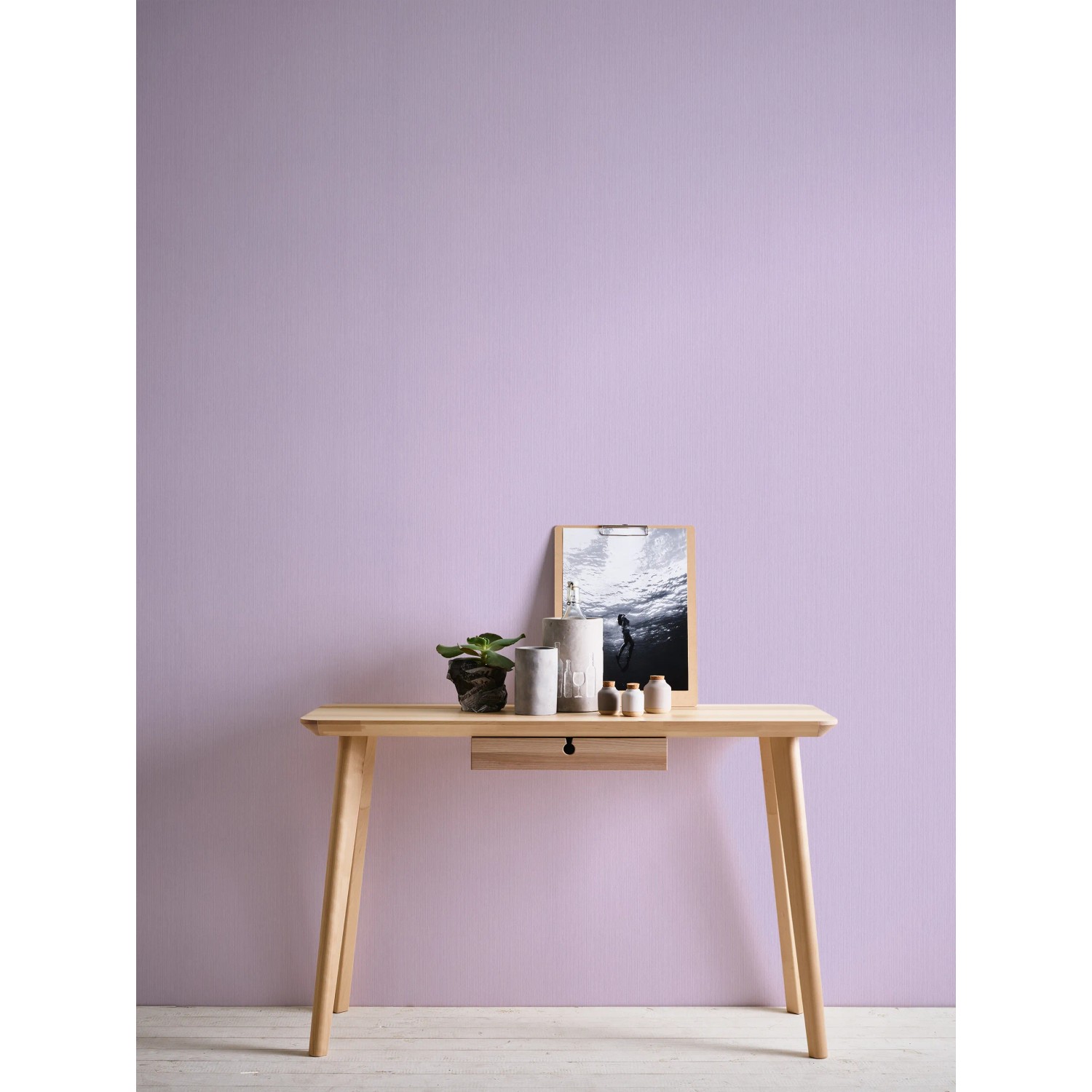 Michalsky Living Vliestapete Uni Lila an Wand hinter Tisch mit Deko.