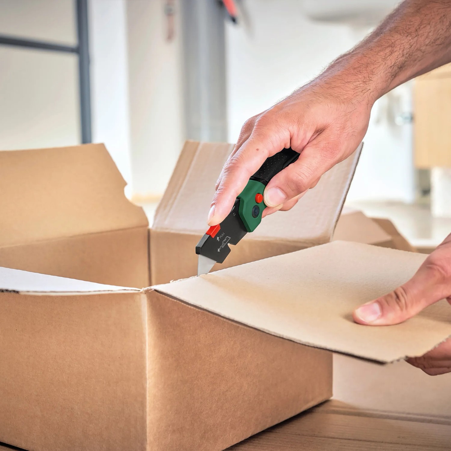 Bosch Klappmesser schneidet Karton. Vielseitiges Messer mit Softgrip und Klingenfach.