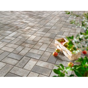 Verlegtes Rechteck-Pflaster Beton Jura-Nuanciert mit Äpfeln im Korb, ideal für Gartenwege.