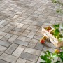 Verlegtes Rechteck-Pflaster Beton Jura-Nuanciert mit Äpfeln im Korb, ideal für Gartenwege.