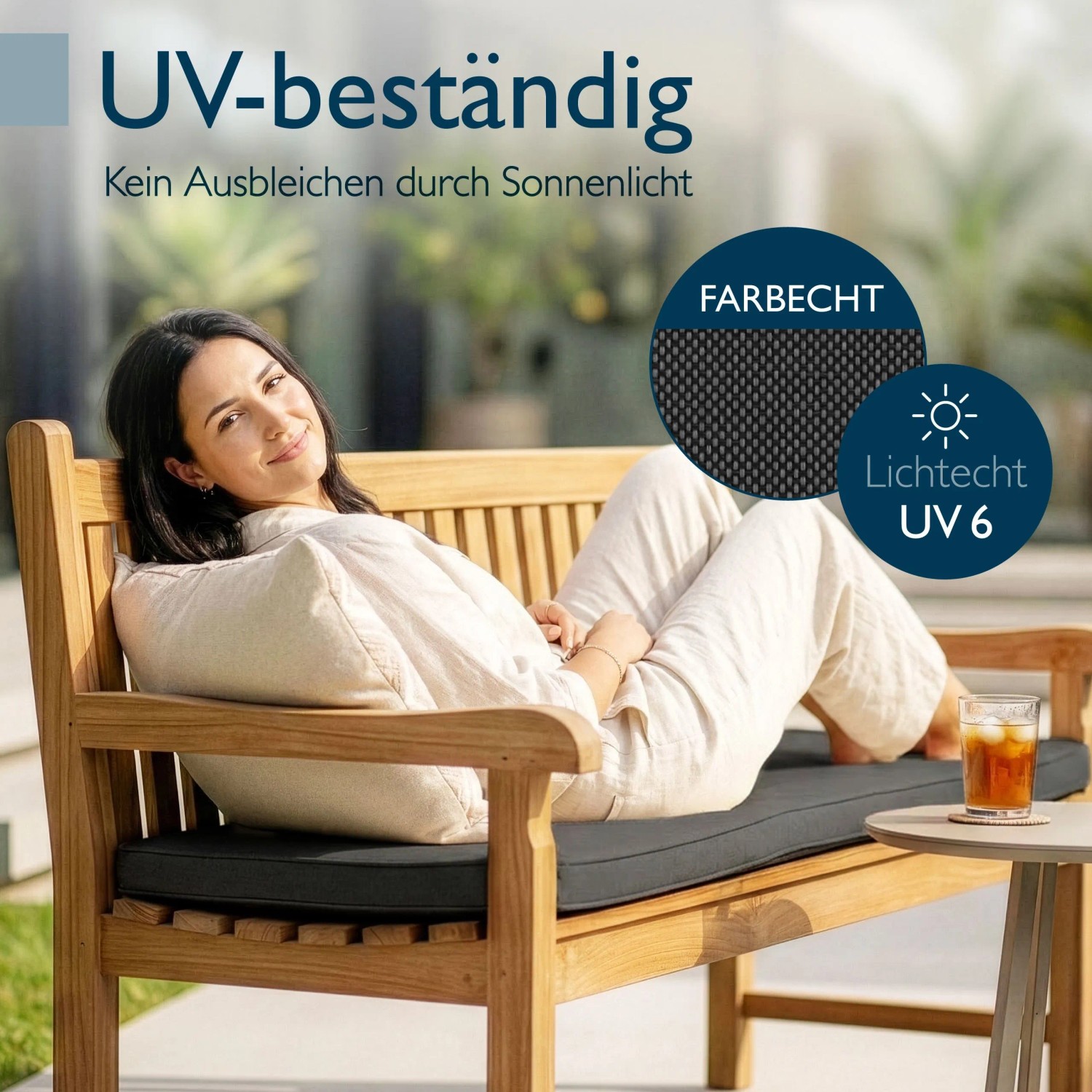 Frau entspannt auf Holzbank mit anthrazitfarbener Beautissu Outdoor Bankauflage. Wetterfest, UV-beständig, waschbar.