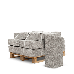 Helle, gebrochene Granit Mauersteine 40x20x20 auf einer Holzpalette, mit Bändern gesichert. Ideal für Gartenmauern.
