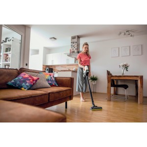 Frau saugt mit Kärcher Akku-Staubsauger VC 4 Cordless myHome Holzboden im Wohnzimmer.