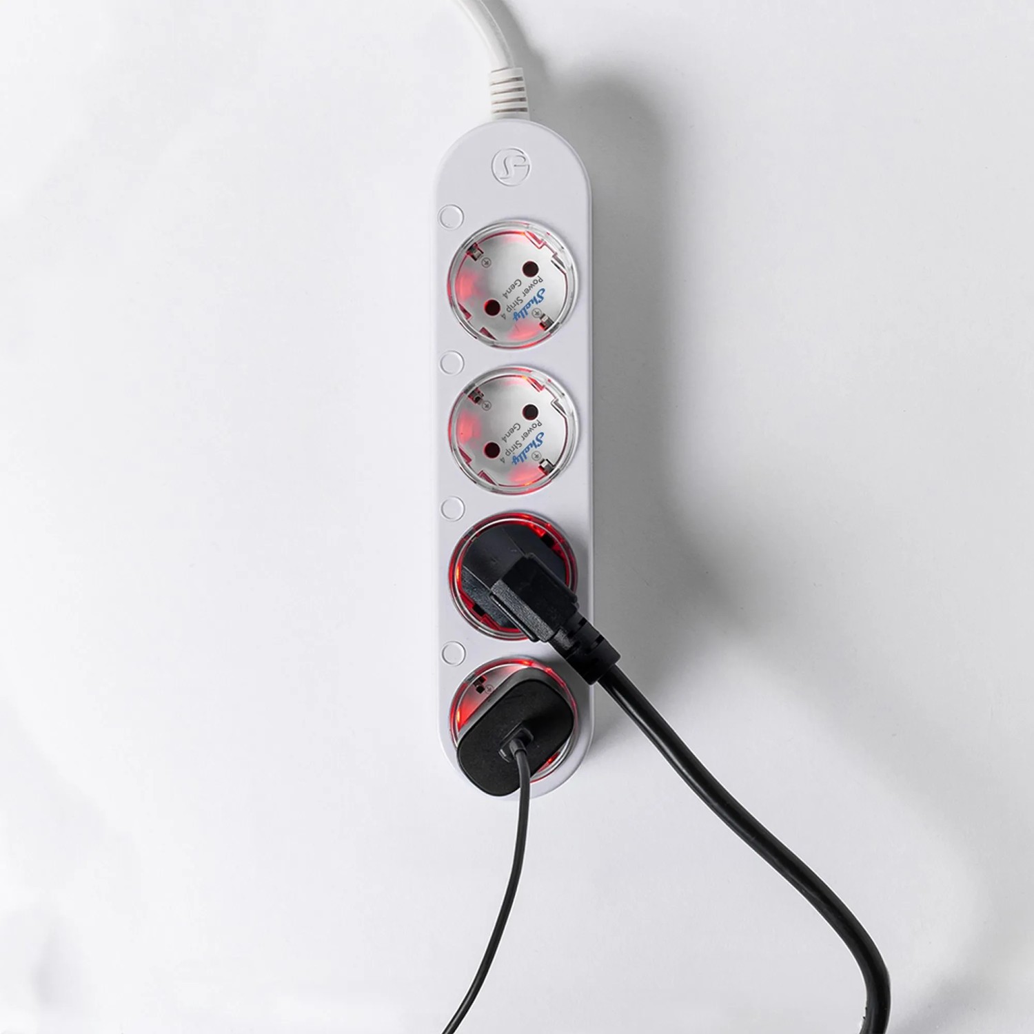 Weiße Shelly Power Strip 4 Gen4 Steckdosenleiste mit zwei eingesteckten Geräten.