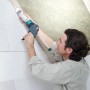 Mann benutzt wolfcraft Kartuschenpresse MG 300 für Silikonarbeiten an Wand und Decke.