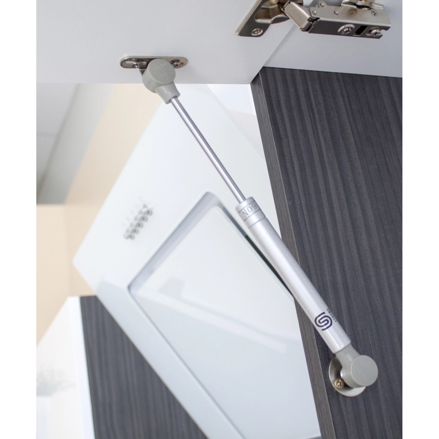 Detailaufnahme: Dämpfer an einem Oberschrank der Respekta Premium Inselküche in Weiß Hochglanz.