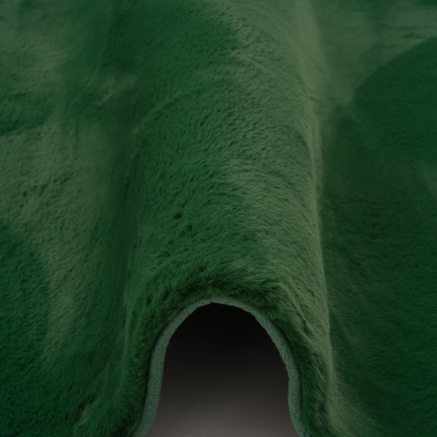 Detailaufnahme: Tannengrüner, superweicher Fellteppich (70x140cm) der Marke Pergamon. Flauschiger Kurzflorteppich.