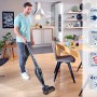 Mann saugt mit dem Leifheit Akku Staubsauger Rotaro PowerVac 2in1 in einer Wohnung.