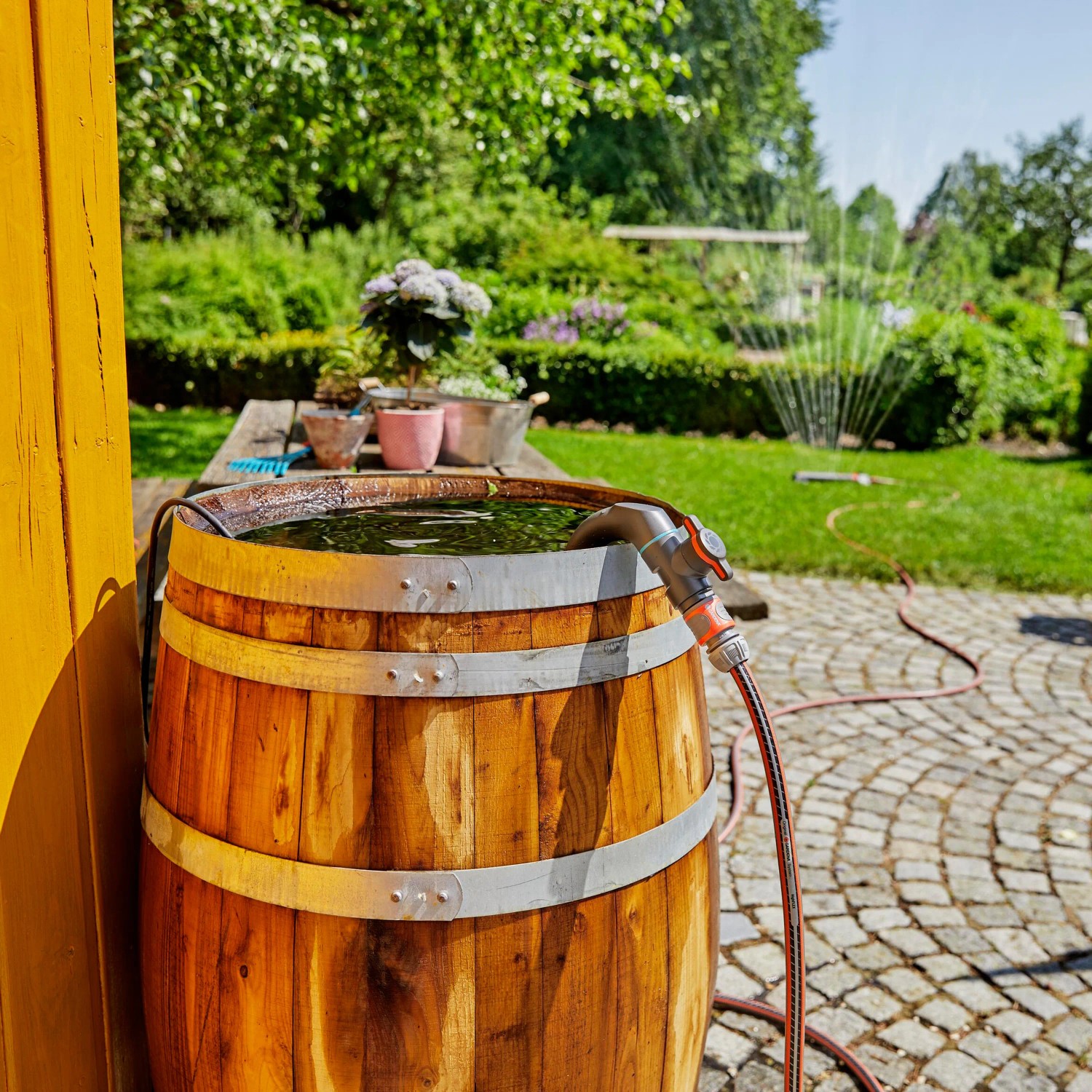 Gardena Regenfasspumpe 4700/2 Inox im Einsatz: Bewässerung mit Gartenpumpe aus Holzfass im Garten.