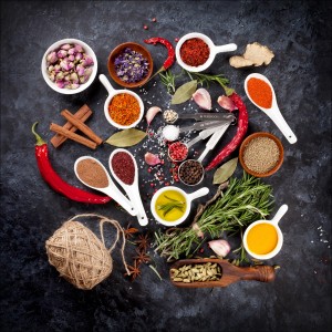 Pro-Art Glasbild Spicery II: Arrangement verschiedener Gewürze und Kräuter auf dunklem Grund.