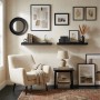 Modernes schwarzes MDF Wandregal mit Metallhalterung, dekoriert mit Büchern und Pflanzen im Wohnzimmer.