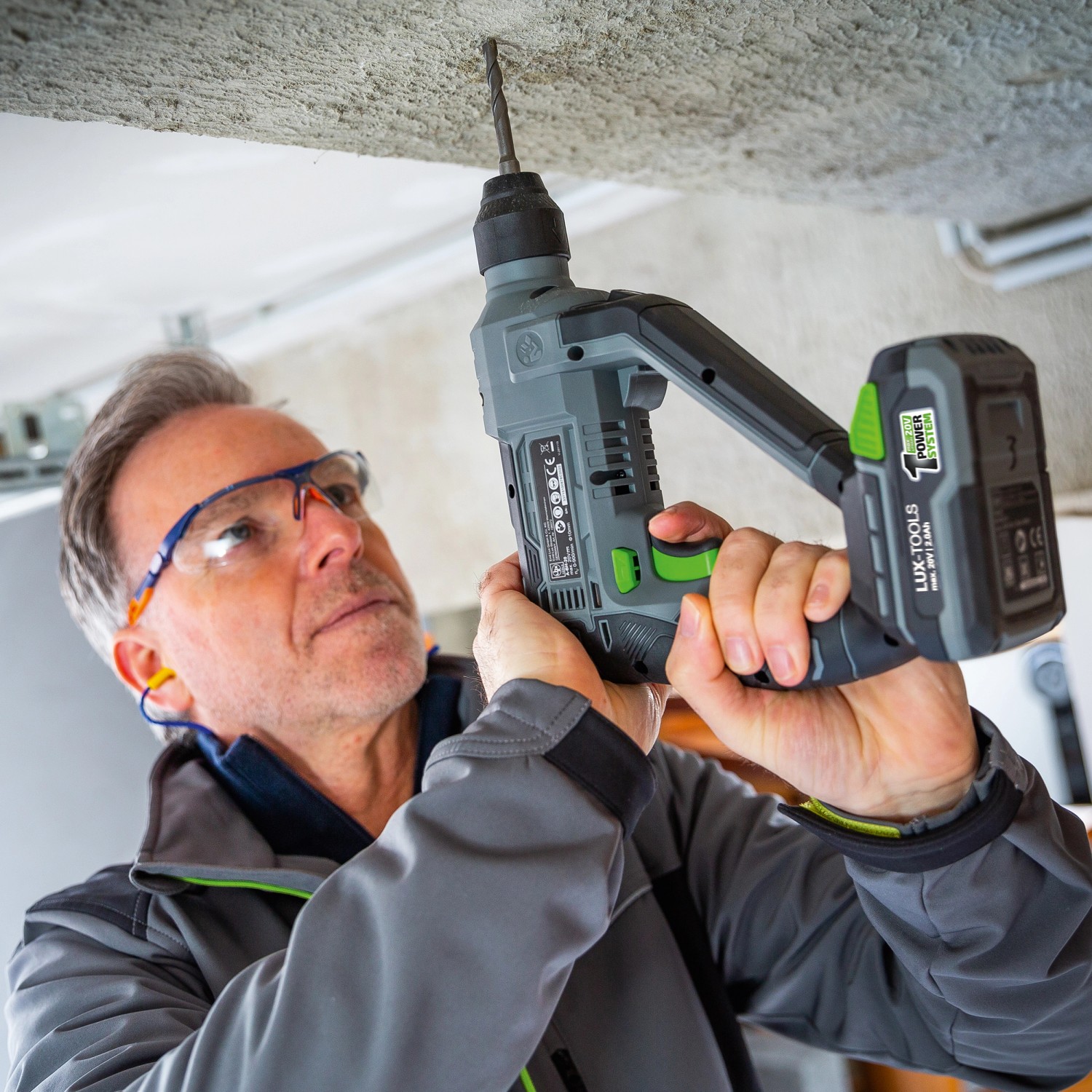 Mann bohrt mit LUX Akku-Bohrhammer A-BH-20 ein Loch in die Decke.