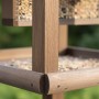 Detailaufnahme: Braun imprägniertes Relaxdays Vogelfutterhaus mit Ständer aus Tannenholz.