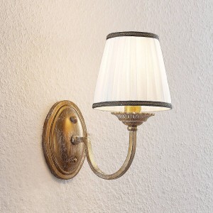 Rustikale Lindby Wandleuchte Lumiel in Bronze mit cremefarbenem Textilschirm. Vintage-Stil für Wohnzimmer.