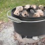 Schwarzer El Fuego Dutch Oven (3,5 l) aus Gusseisen mit Kohlen auf dem Deckel (1 l).