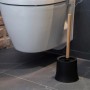 Wenko WC-Garnitur Basic Bambusa mit schwarzem Behälter und Bambus-Stiel vor einer Toilette.