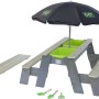 EXIT Aksent Sand- und Wassertisch mit Bänken, Sonnenschirm und Gartenwerkzeug.