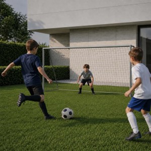 Drei Jungen spielen Fußball im Garten mit einem grauen Stahl-Fußballtor. Robustes Sport & Fitnessgerät.