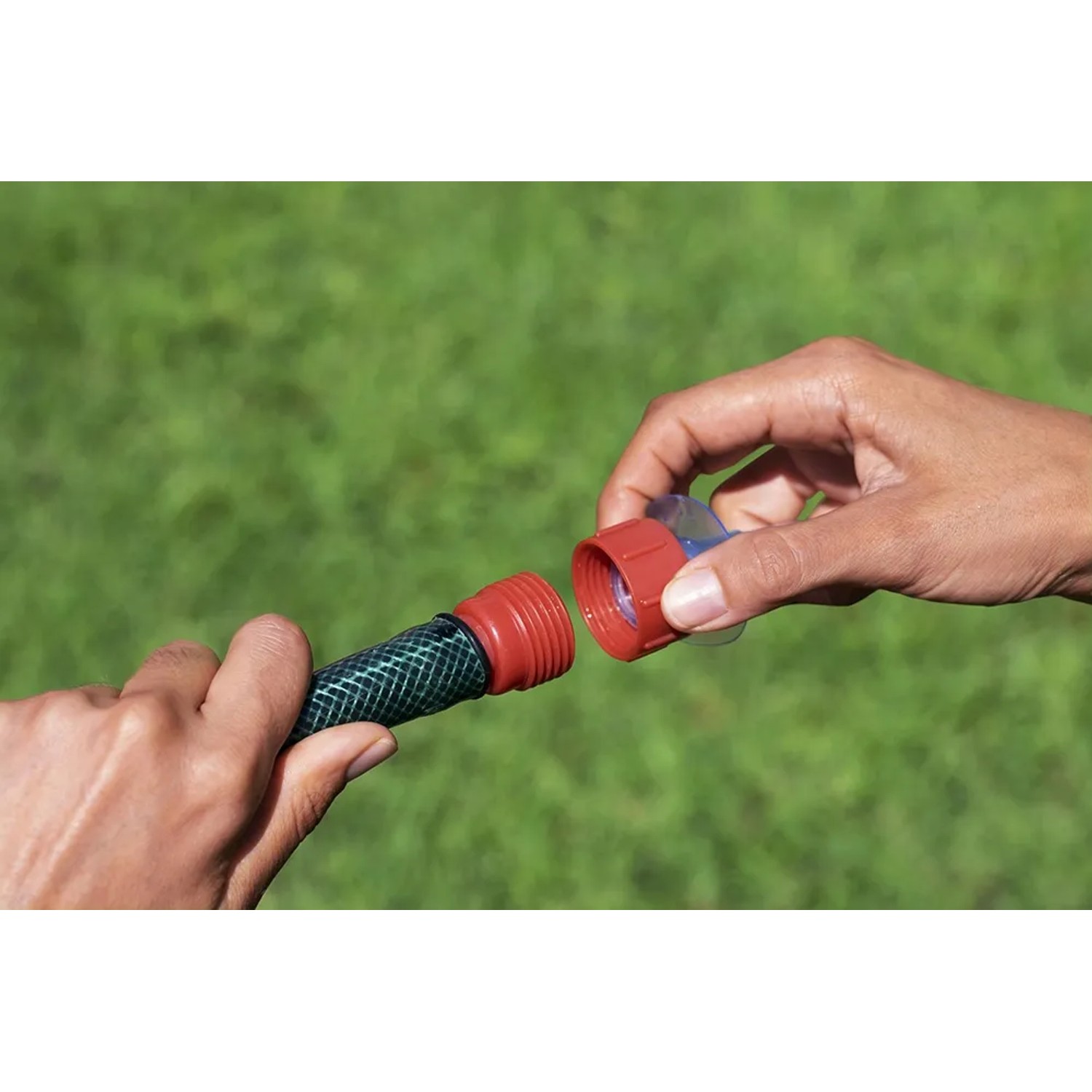Gartenschlauch-Verbinder wird zusammengesteckt für Wassersprinkler und Spiele.