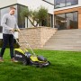 Ryobi Akku-Rasenmäher RY18LM37A-140 im Einsatz: Mann mäht Rasen vor modernem Haus.