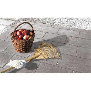 Diephaus Terrassenplatten Siva mittelgrau, 60x40 cm, in Schieferoptik verlegt. Korb mit Äpfeln und Rechen liegen darauf.