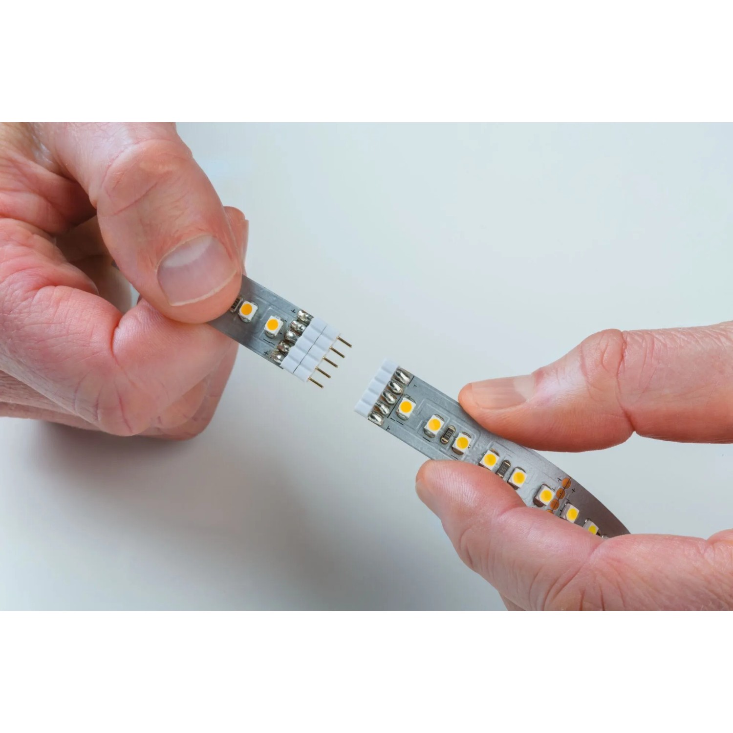Hände verbinden Paulmann LED-Streifen MaxLED 1000 Neutralweiß. Einfaches Stecksystem für flexible Montage.