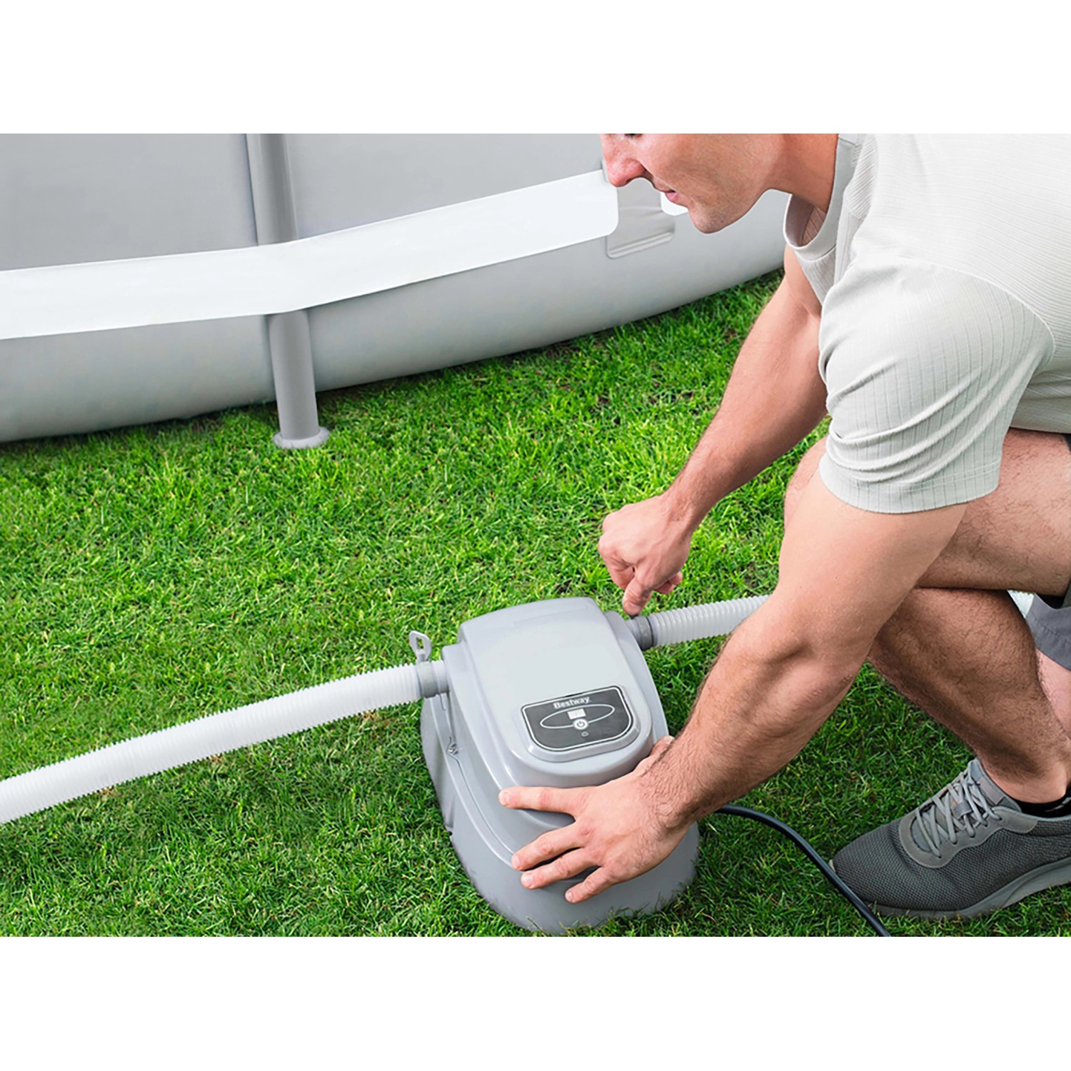 Bestway Pool Heizgerät im Einsatz: Graues Gehäuse mit Schlauchanschluss auf Rasen neben Pool.