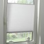 Weißes Gardinia Plissee Concept Tageslicht, flexibel verstellbar am Fenster.