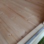 Innenansicht Gartenhaus Angolo B: Holzboden aus hellem Nadelholz mit Türrahmen.