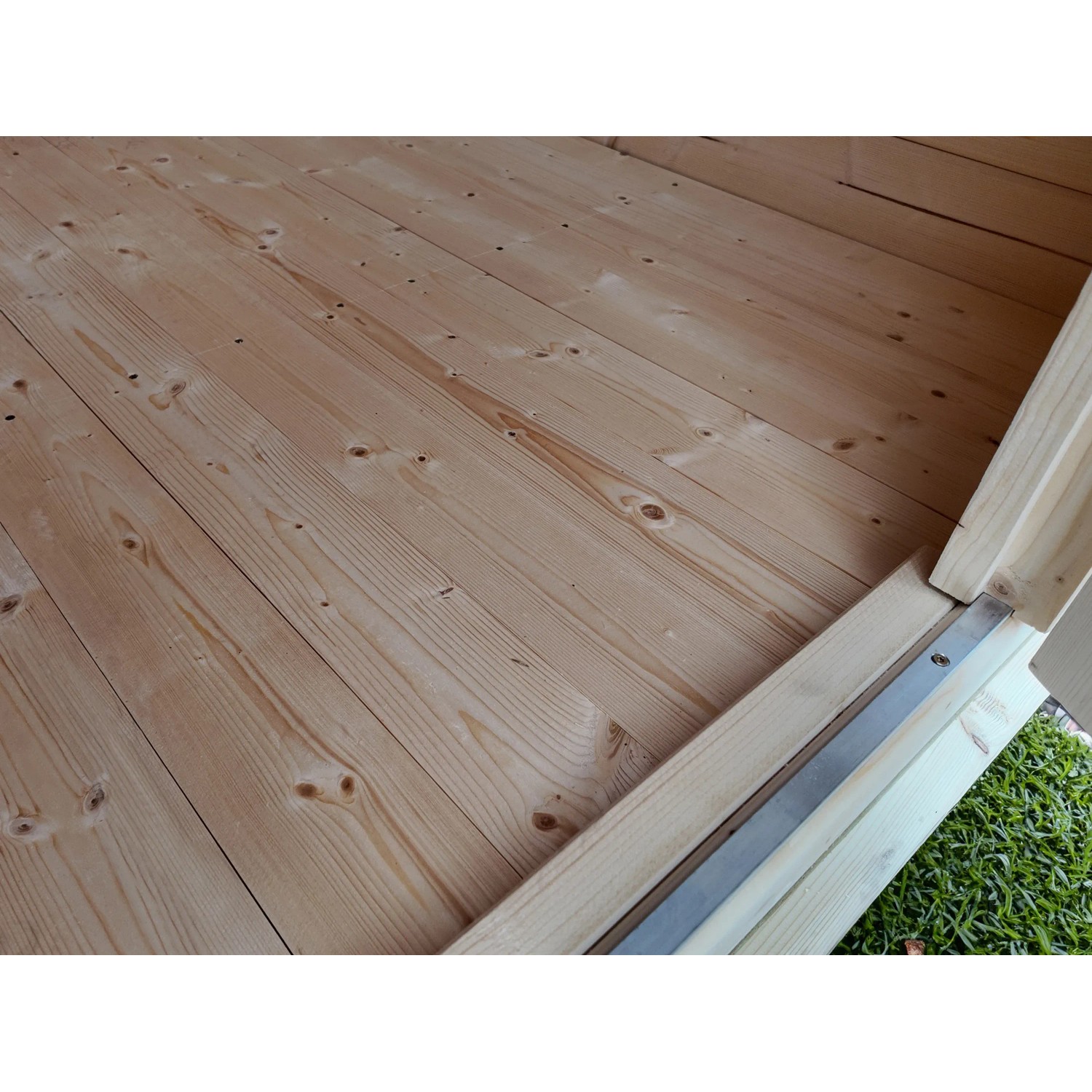 Innenansicht Gartenhaus Angolo B: Holzboden aus hellem Nadelholz mit Türrahmen.